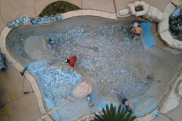 Aerial view of the pool with chipped-out plaster rubble covering the entire floor