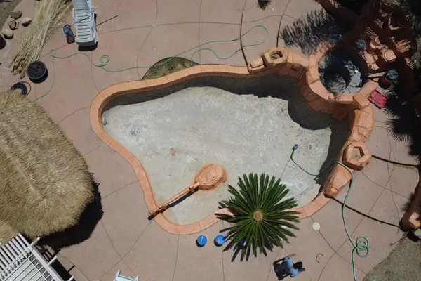 Aerial view of the pool stripped back to bare structural shell with the rubble cleared